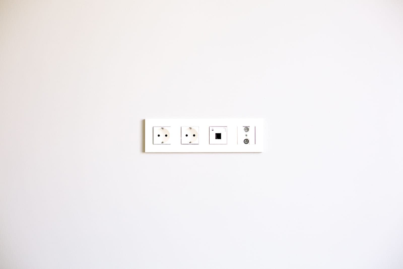 A white electrical outlet on a bathroom wall
