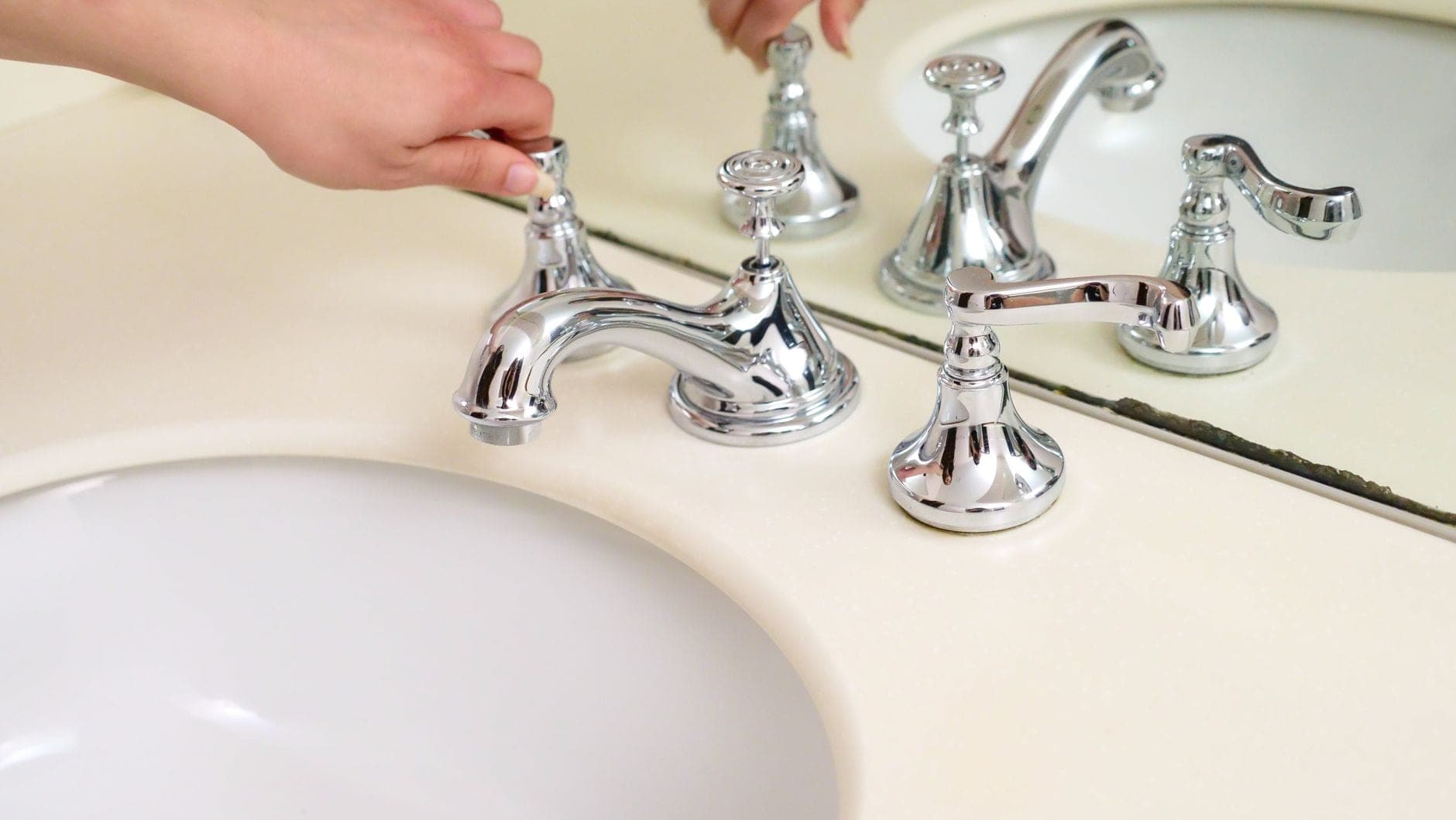 A chrome widespread faucet with separate handles on a bathroom sink