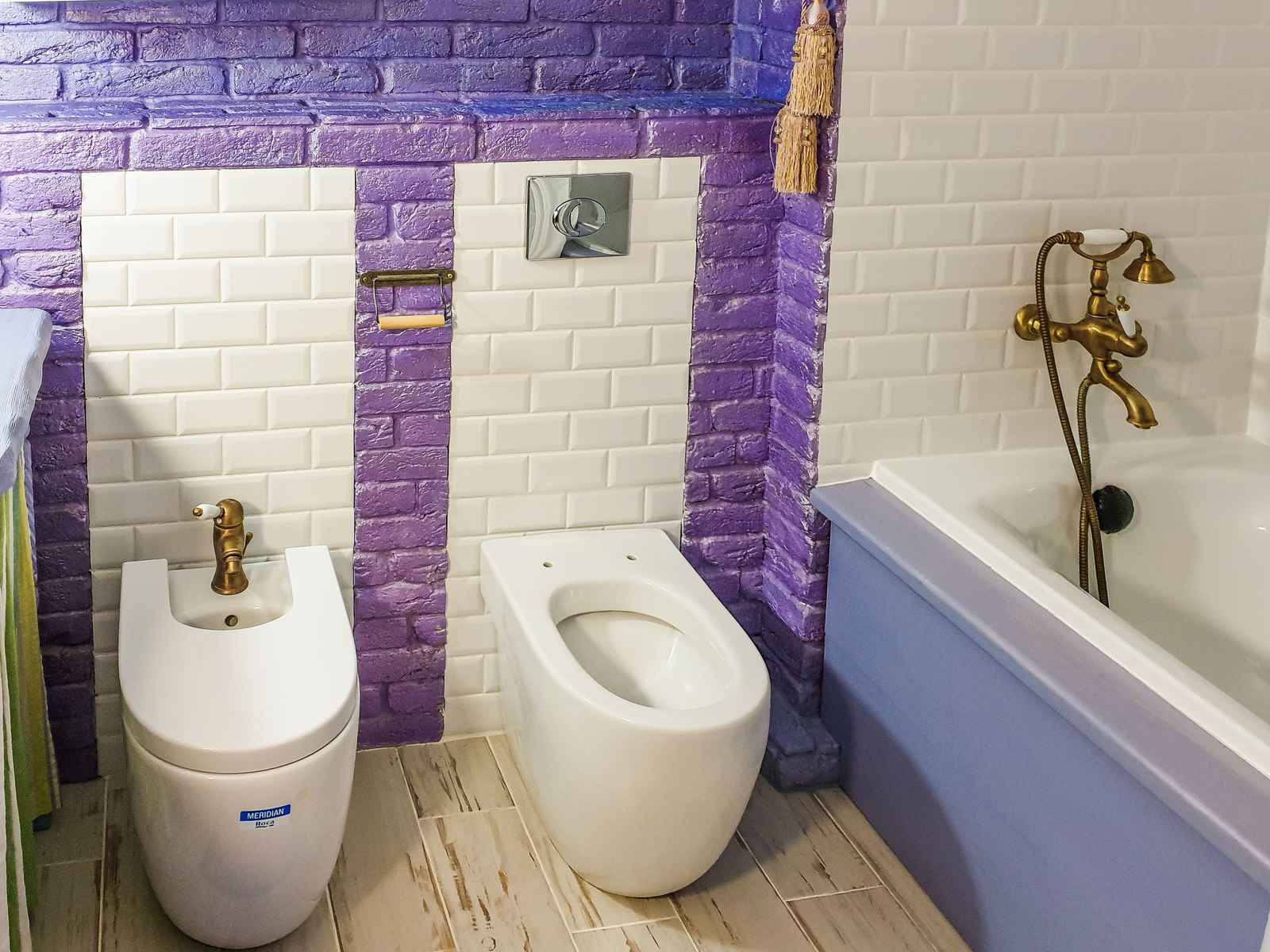 A white toilet against a tiled wall