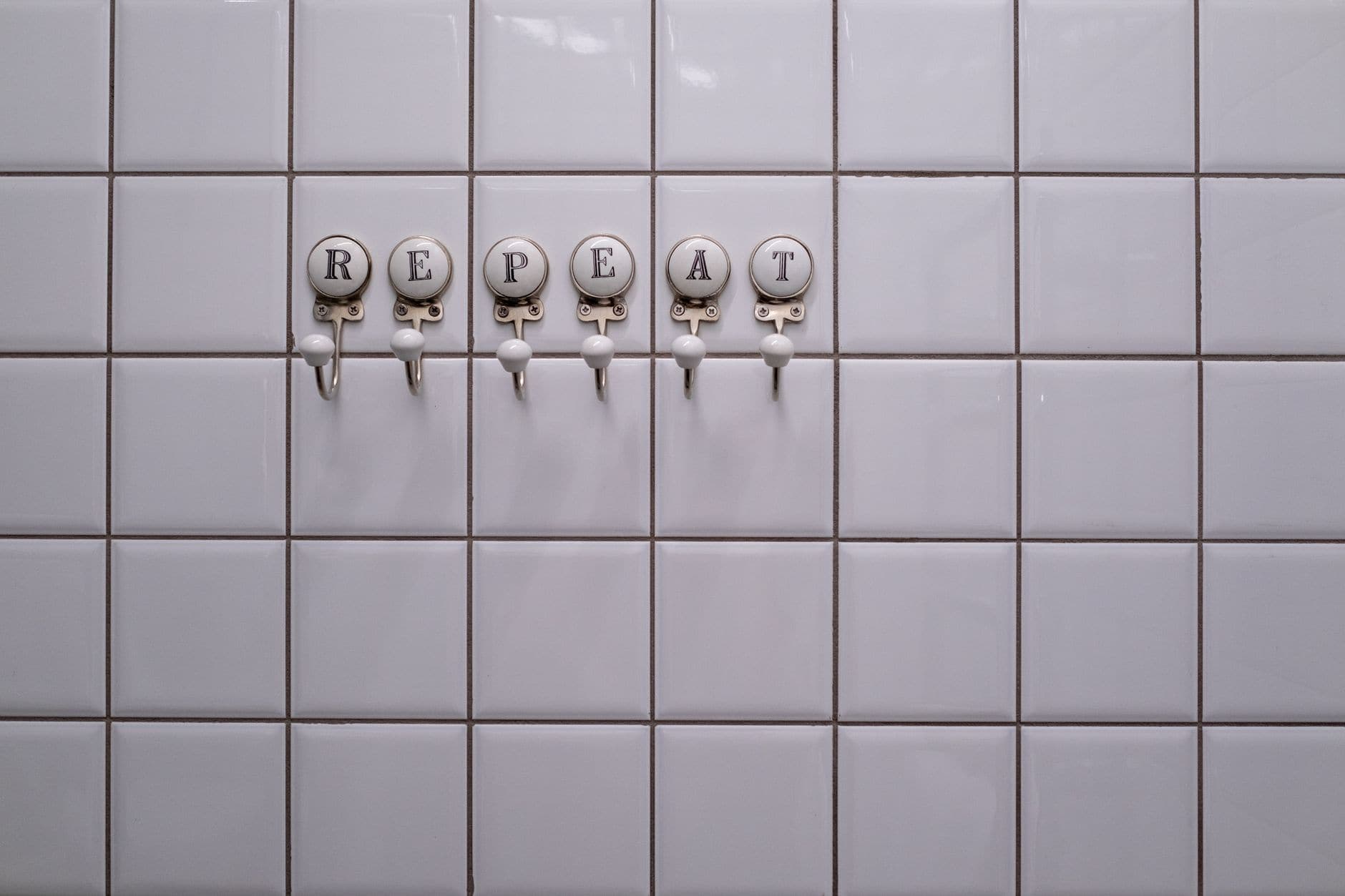 A towel hook and a towel bar on a bathroom wall