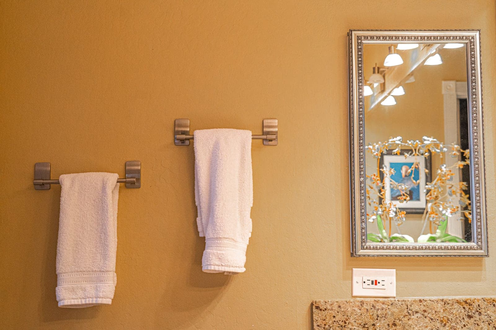 A towel bar with a hand towel against a white wall