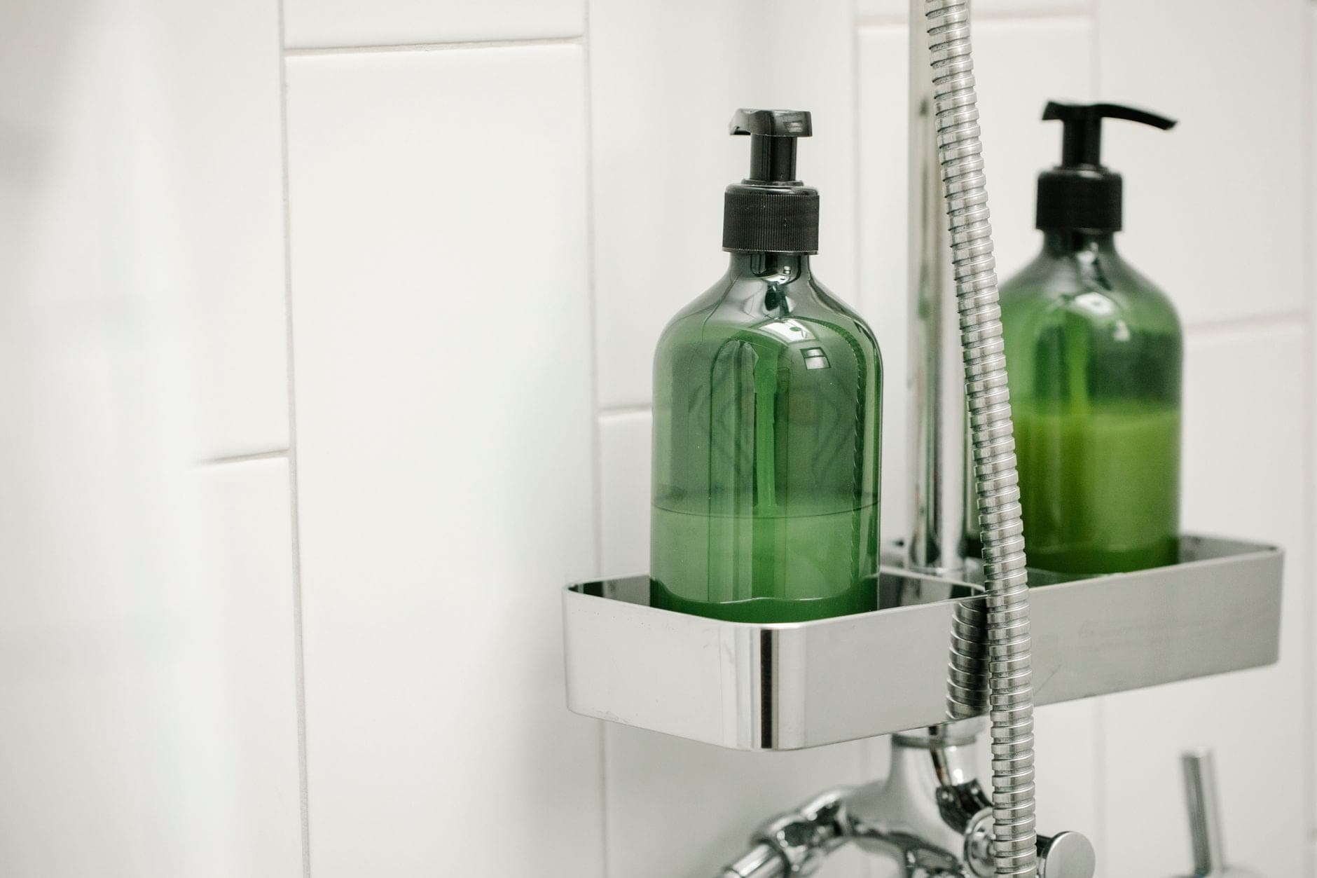 A shower caddy holding bottles in a tiled shower