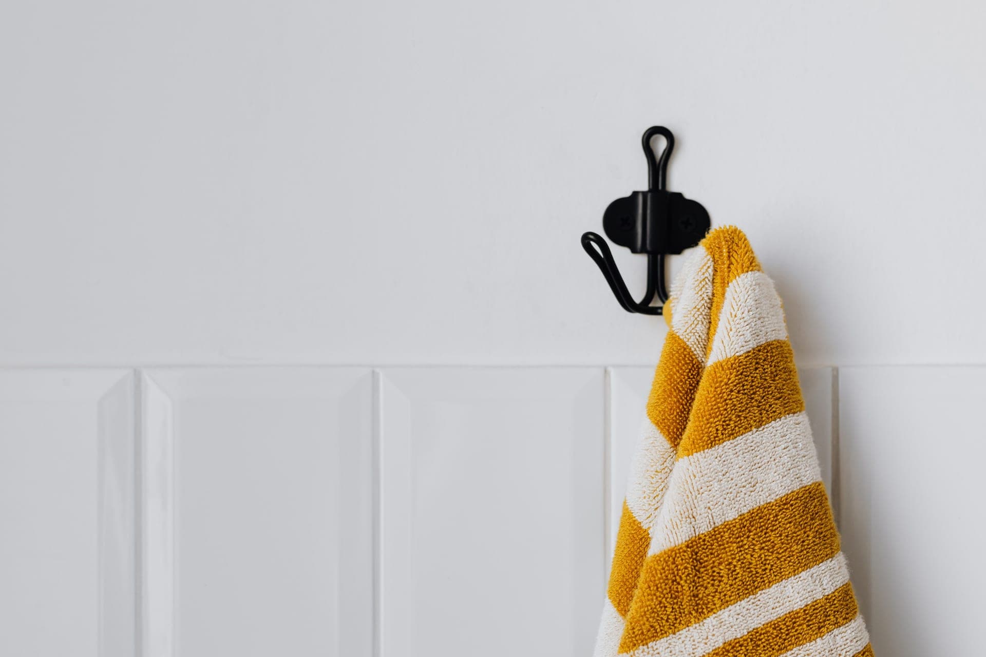 A hook on a tiled bathroom wall