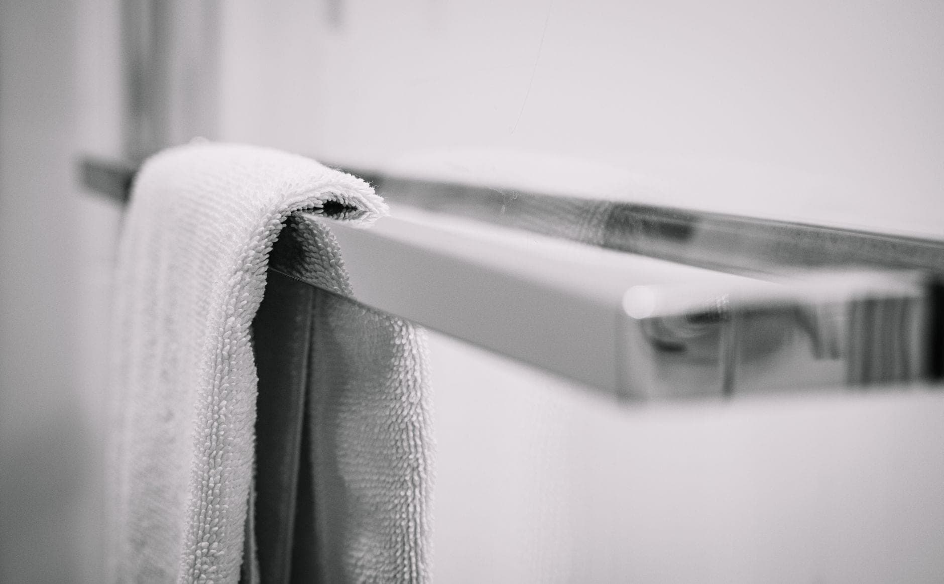 A towel folded over a chrome towel bar