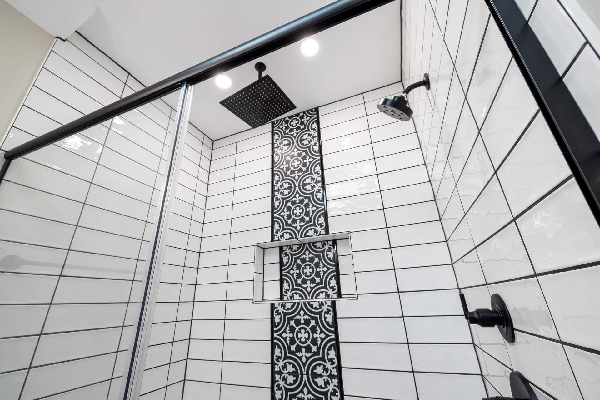A shower head high on a tiled wall