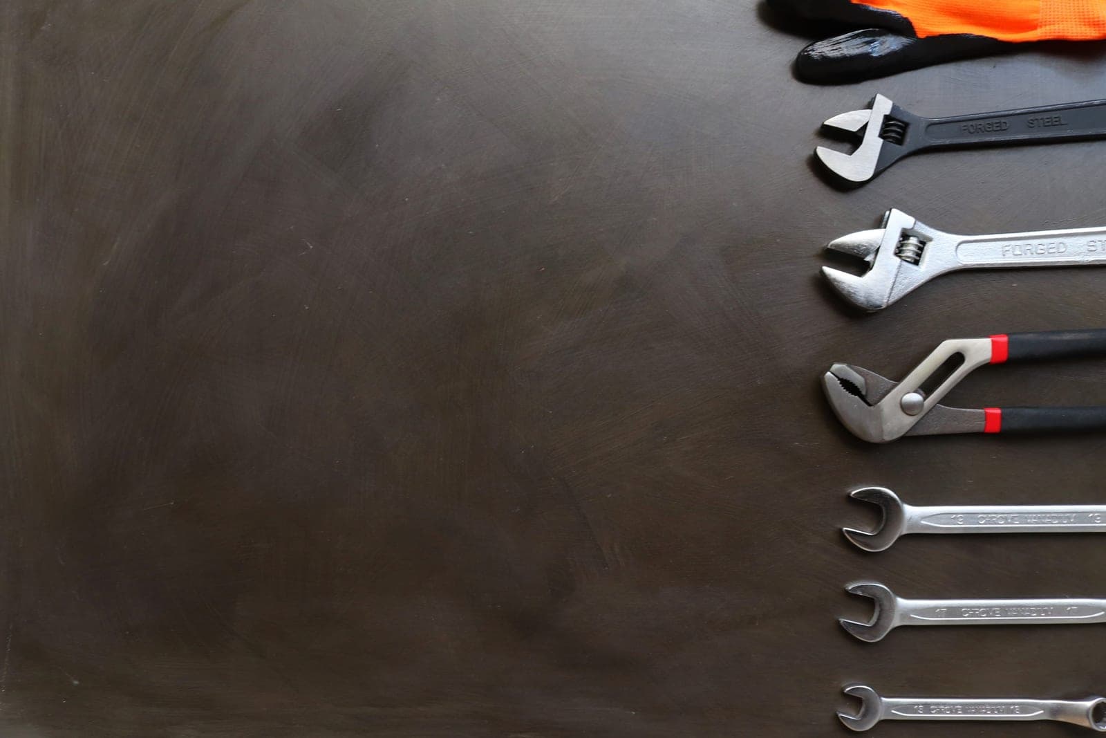 A hand holding an adjustable wrench during a plumbing repair
