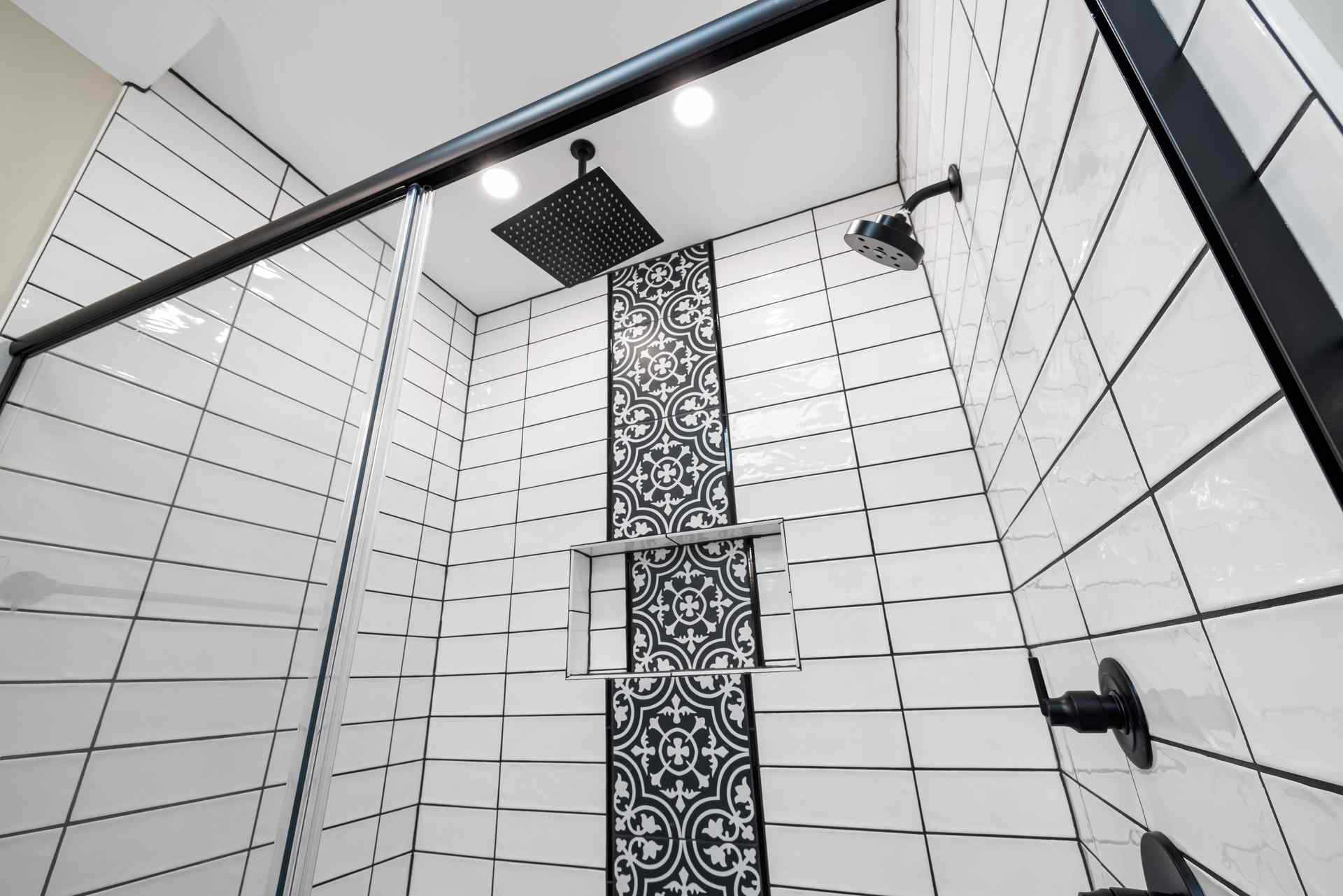 A matte black shower head against a pale wall