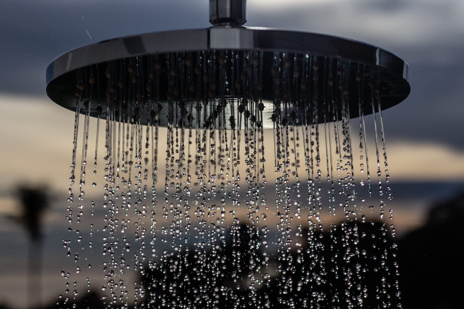 Water falling from a ceiling-mounted rain shower head