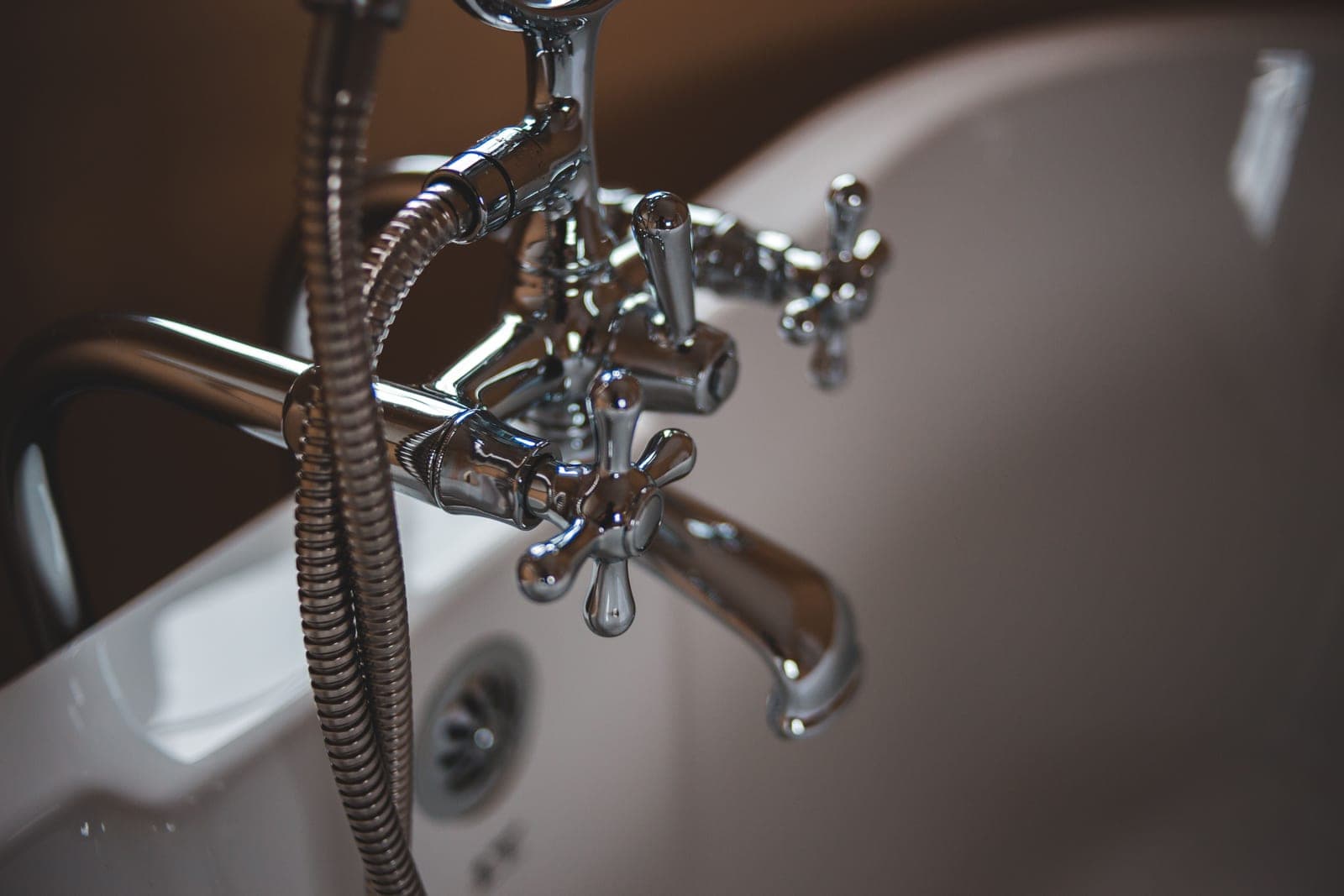 A bathtub faucet spout with water running