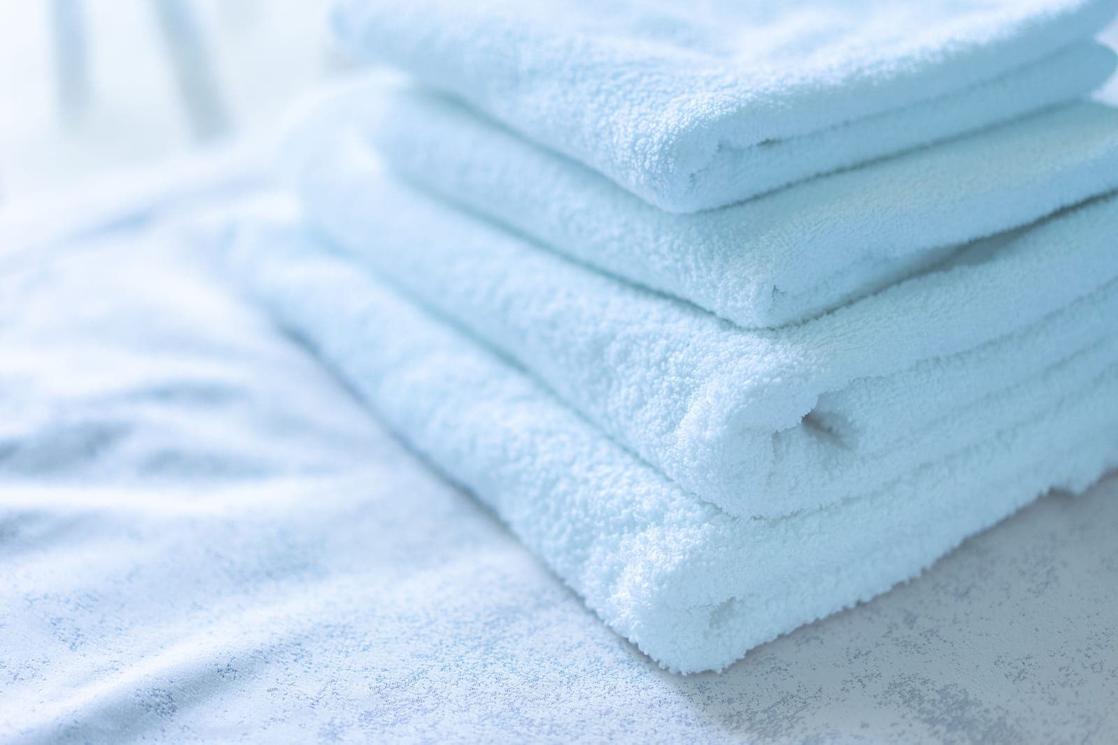 A stack of folded pale cotton bath towels