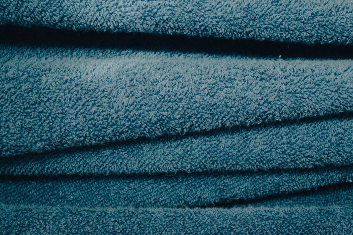 A close-up of folded blue terry cotton towels
