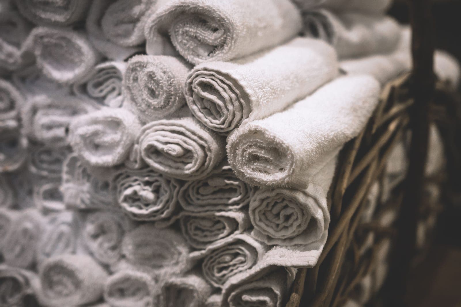 Rolled white towels in a basket